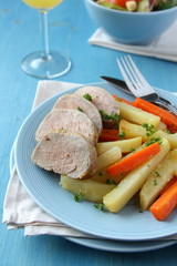 Sliced roast pork tenderloin with potatoes and carrots