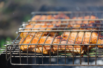 Roasted meet during cooking on the mesh in open fire