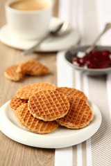 Mini stroopwafels (syrupwaffles) with cup of coffee and jam