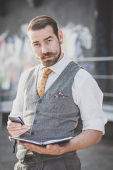 handsome big moustache hipster man with diary and smartphone