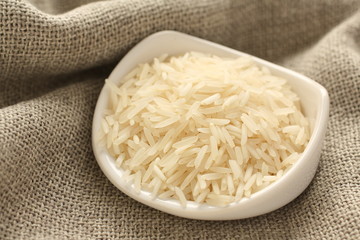 Polished long rice grains in white ceramic bowl