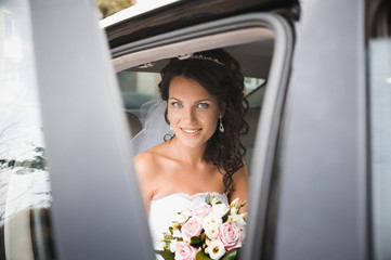 Fototapeta na wymiar Young bride in a wedding car