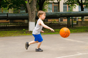 Fototapeta premium Little boy playing basketball