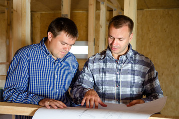 Two builders discussing a building plan