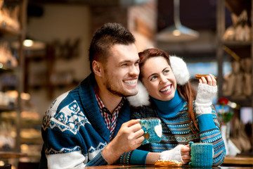 Young couple with coffee at the cafe in winter