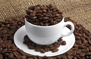 Coffee beans in cup, on a burlap background