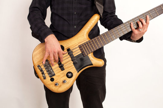 Close up of a brown bass guitar with hands