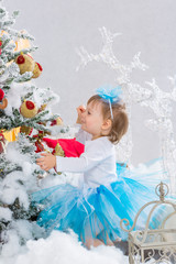 Little girl  is decorating christmas tree