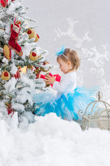 Obraz na płótnie Canvas Little girl is decorating christmas tree