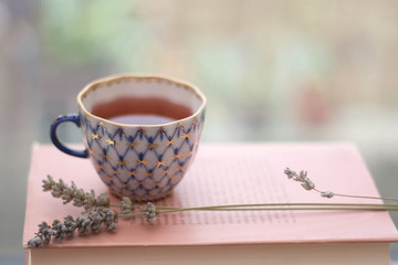 Tea in a vintage porcelain cup, with lavender and old book