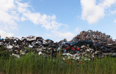 Scrap yard with crushed cars and blue sky