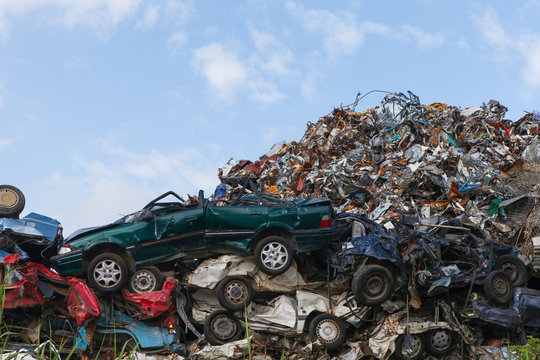 Scrap yard with crushed cars and blue sky