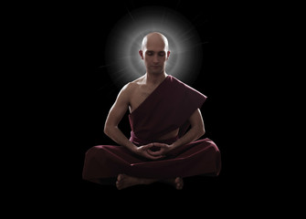 buddhist monk in meditation pose over black background