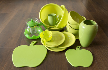 green dishes on a dark wood floor