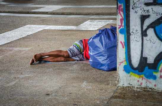 Homeless man sleeps under overpass