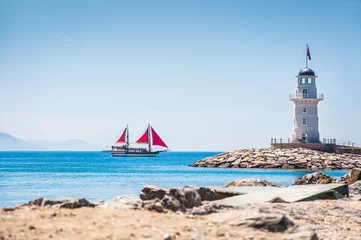 Fototapete Leuchtturm und Touristenyacht am Meer © smallredgirl