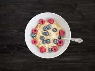 Gordijnen Oat porridge with fresh raspberry, blueberry and honey © sonyakamoz