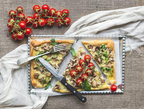Rustic mushroom (fungi) square pizza with cherry tomatoes and ar