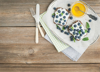 Healthy breakfast set with ricotta, fresh blueberries, honey and