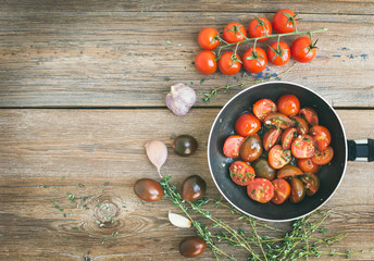 Roasted cherry-tomatoes with garlic and thyme in a cooking pan o