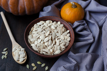 Bowl with toasted pumpkin seeds and wooden spoon
