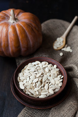 Bowl with toasted pumpkin seeds and wooden spoon