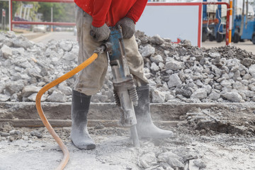 worker using construction drilling cement on the ground - obrazy, fototapety, plakaty