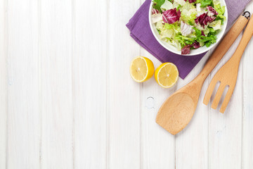 Fototapeta na wymiar Fresh healthy salad and kitchen utensils