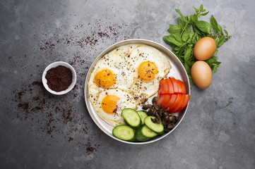 Fired eggs presentation with mints, tomato, olive and cucumber