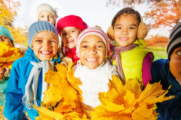 Close up view of happy cute kids with leaves bunch