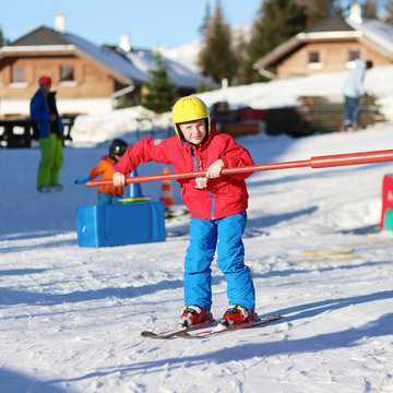 Happy school boy enjoying winter ski vacation