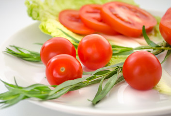 Fresh tomatoes, tarragon, onions on a plate