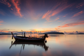 Naklejka na ściany i meble Silhouettes of longtail boat and sunrise in Phuket, Thailand