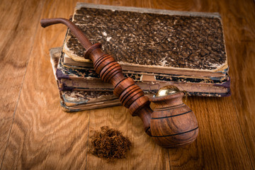 old books and tobacco pipe on wooden table, vintage style