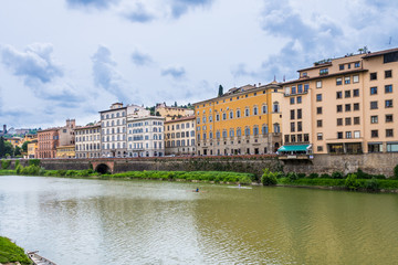 Fototapeta na wymiar Glimpse of Arno river at Ponte Vecchio in Florence on a cloudy