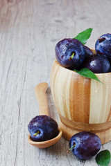  plums in wooden bowl