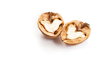 Two halves of walnut with hearts on white background