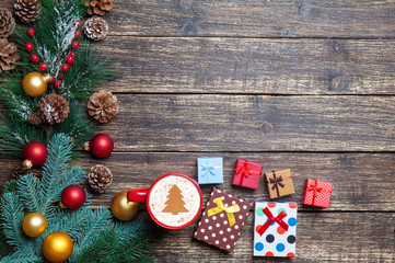 Cappuccino with christmas tree shape and gift on wooden table.