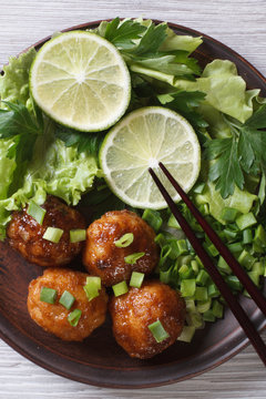 Fish balls with herbs and chopsticks close-up. top view vertical