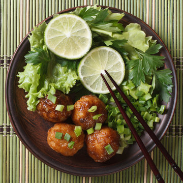 fish balls with lime and fresh herbs on a bamboo table top view