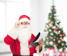man in costume of santa claus with notepad