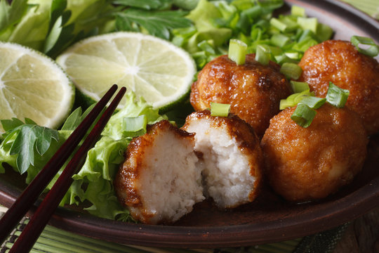 fish balls with lime and salad on a plate macro. horizontal