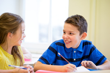 group of school kids writing test in classroom