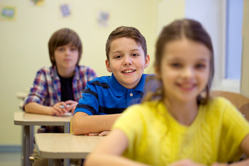 Fototapeta premium group of school kids with notebooks in classroom