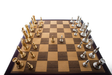 Chess match underway with gold and silver pieces.