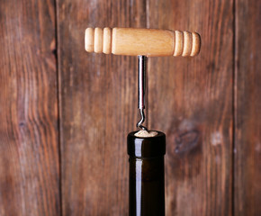 Bottle opener close-up, on wooden background