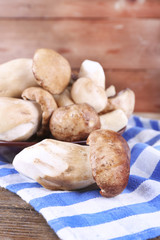 Wild mushrooms on plate on wooden background