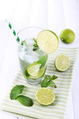 Lemonade in glass on napkin on bright background