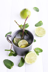 Lemonade in metal cup on wooden background