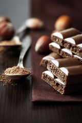 Tasty porous chocolate with nuts on table, close up